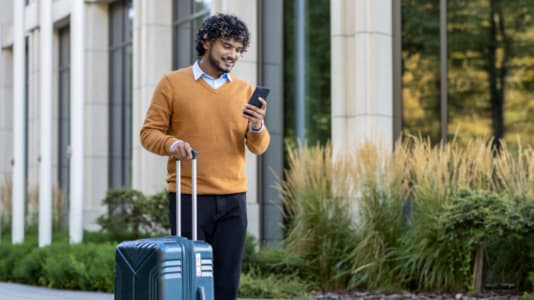 Man med telefon och resväska