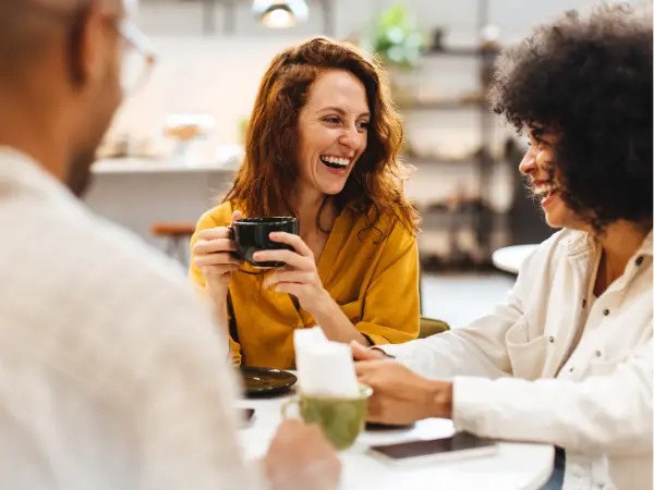 Kolme ihmistä istuu pöydän ääressä