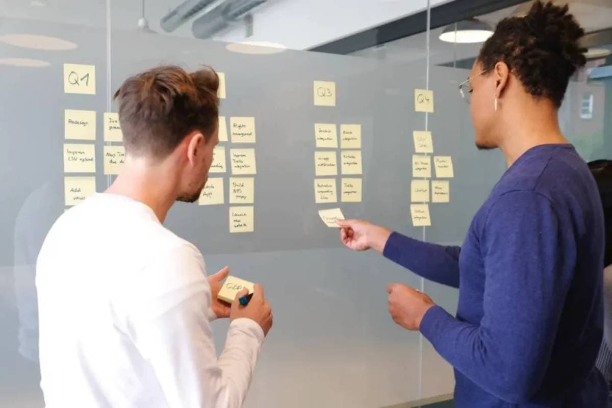 Two people in front of a white board