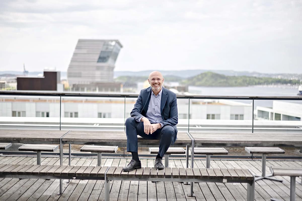 Nainen istuu kannettavan tietokoneen ääressä ja näyttää väsyneeltä.