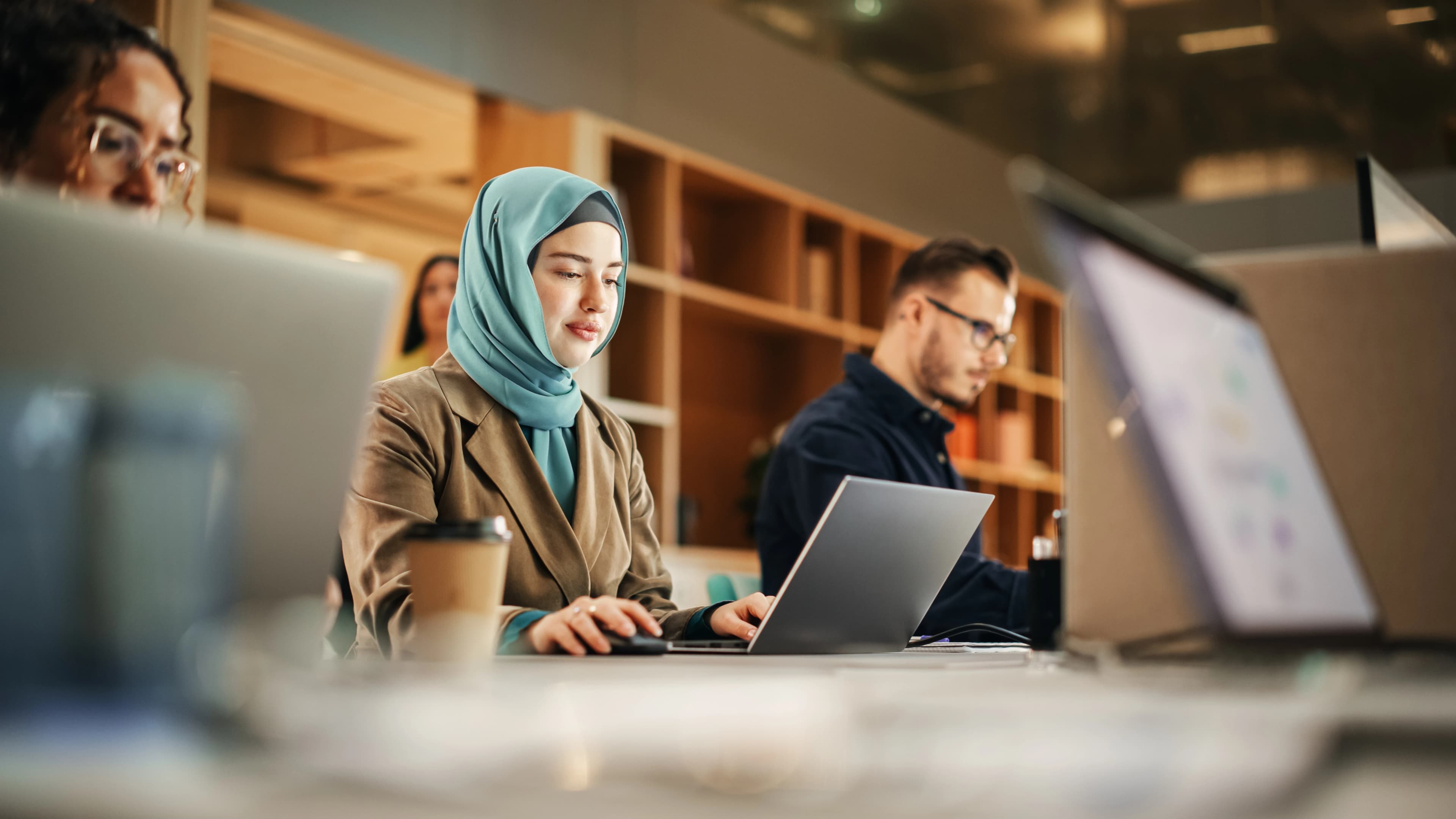 two women and one man sitting at a desk